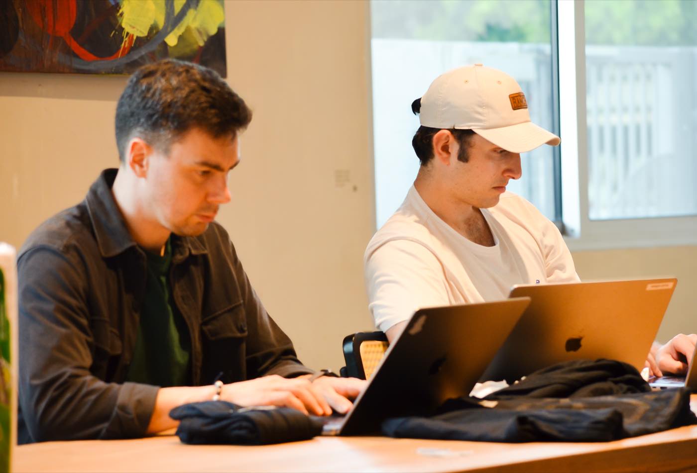 Builders working side by side on laptops